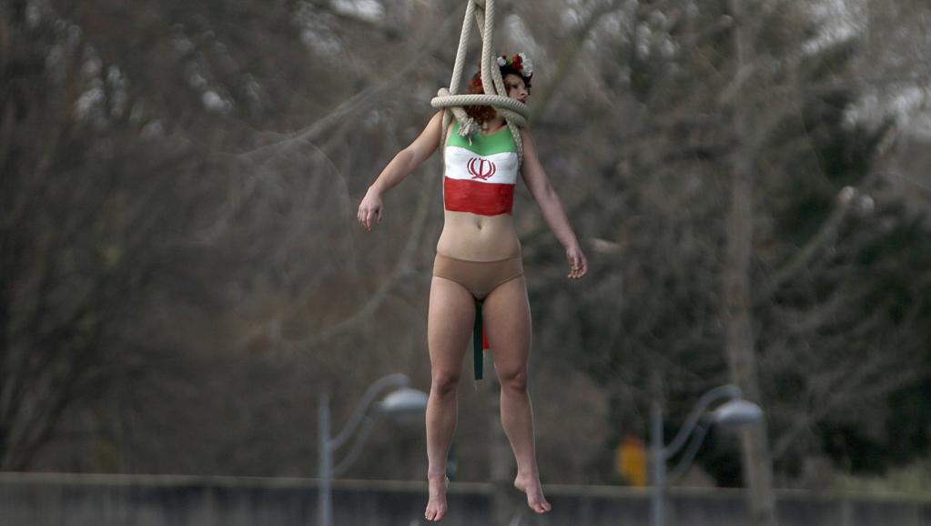 اعتراض به سفر حسن روحانی: یک زن نیمه برهنه خود را از پل حلقه‌آویز کرد